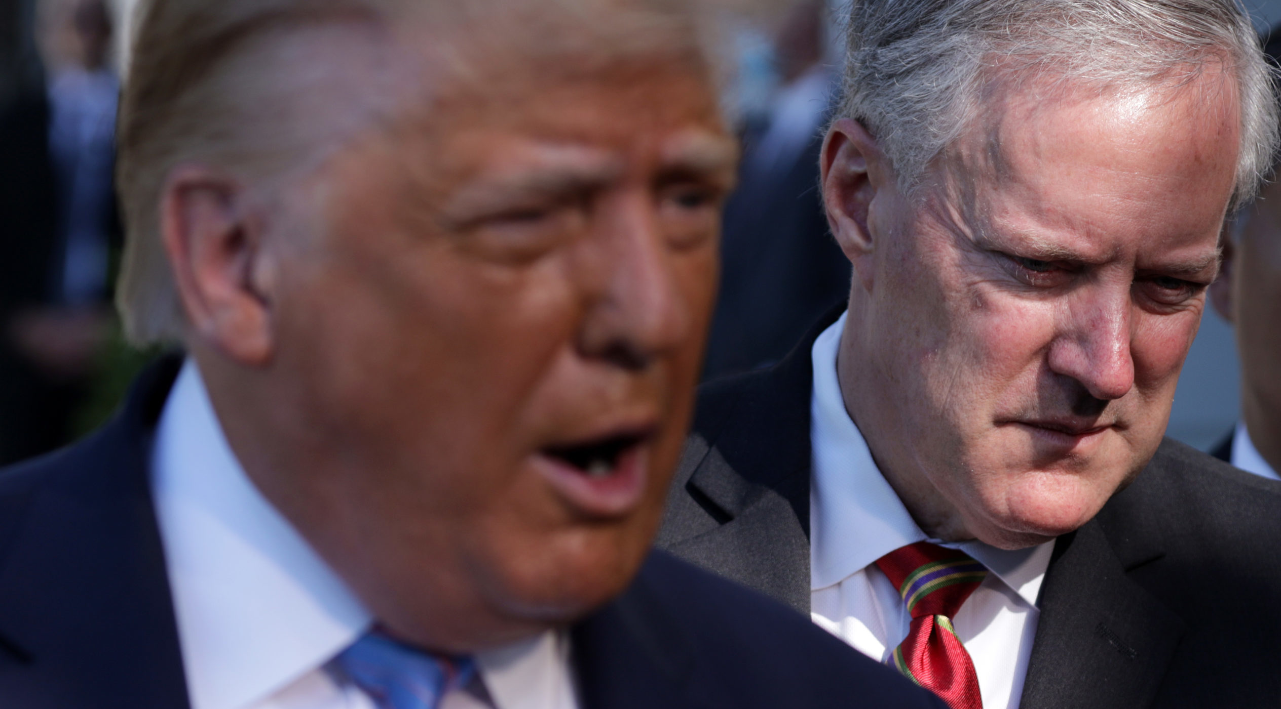 Trump speaks as White House Chief of Staff Mark Meadows stands behind him prior to Trump's Marine One departure from the South Lawn of the White House July 29, 2020 in Washington, DC.