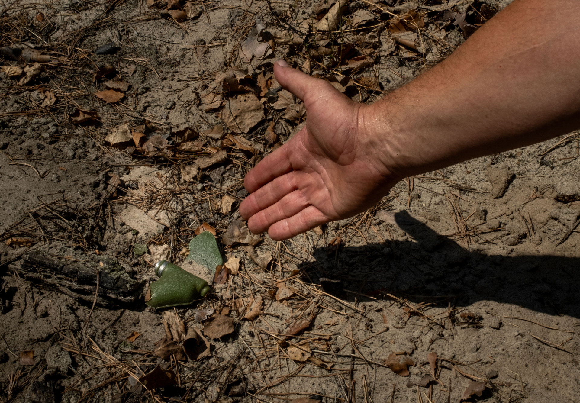 A Krasnolymanske forestry worker points to one of the many butterfly mines that contaminate the forests on July 18, 2024 in the direction of Lyman, Ukraine. (Photo by Ethan Swope/Getty Images)
